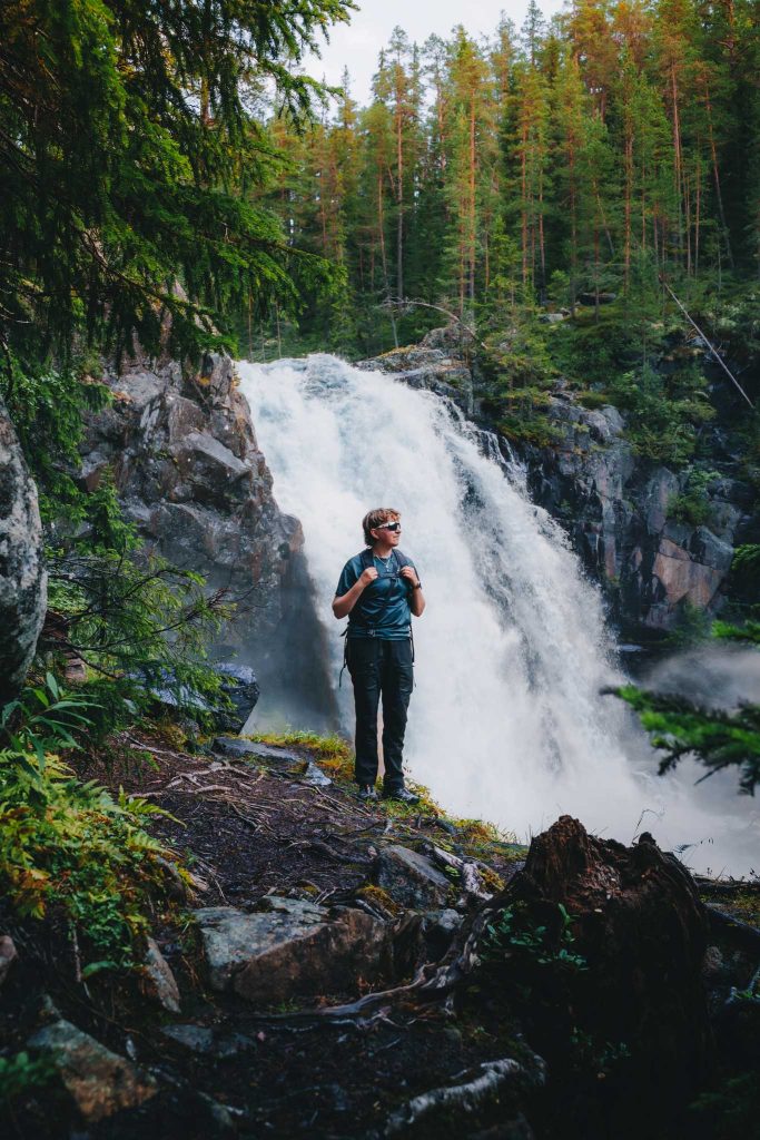 Person framför forsande vattenfall i Norge